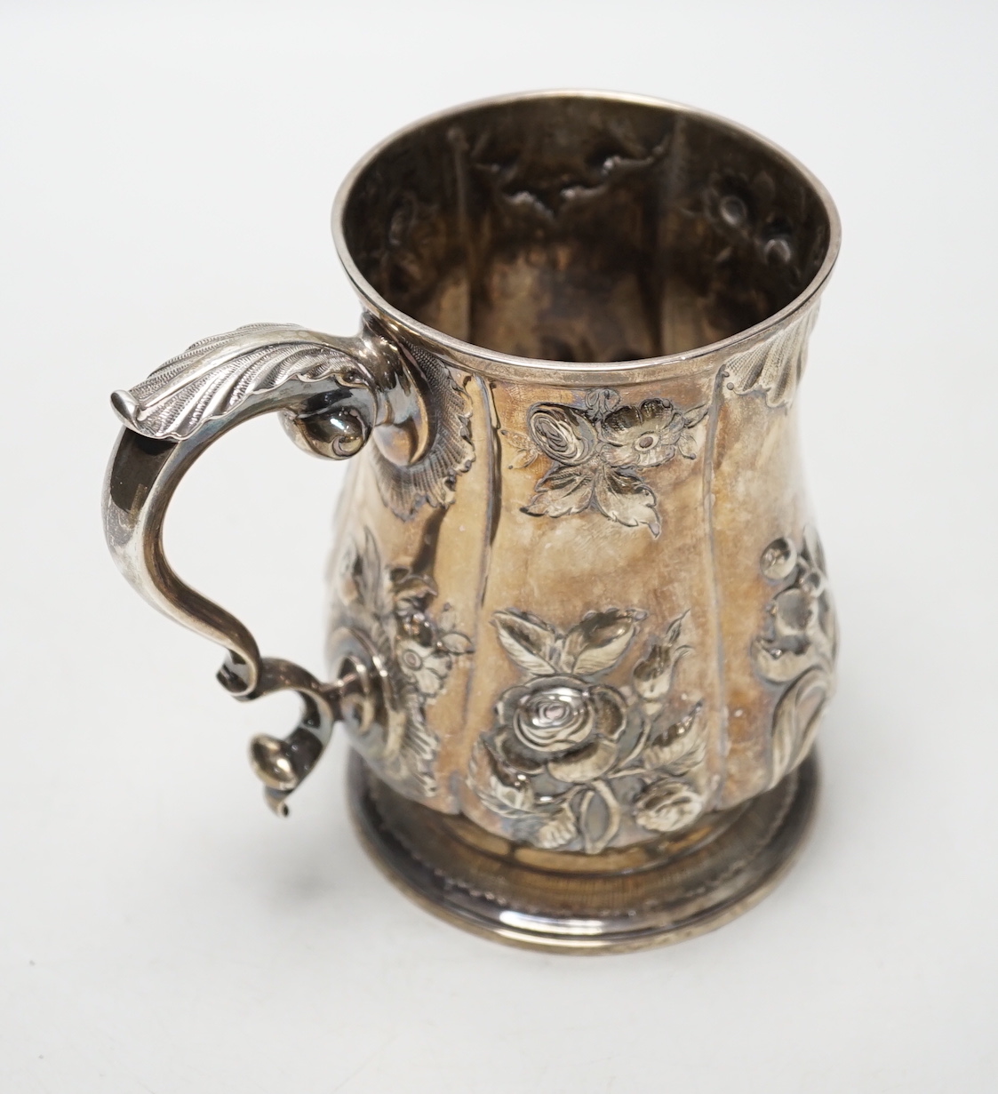 A George III silver baluster mug, with later embossed decoration, Joseph Steward?, London, 1763, 12.9cm, 11.8oz.